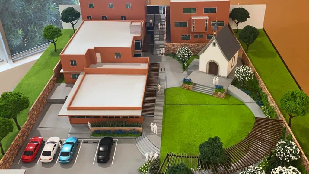 Maqueta de la Casa del Movimiento: terraza en el edificio frontal izquierdo, santuario a la derecha y jardín al frente.